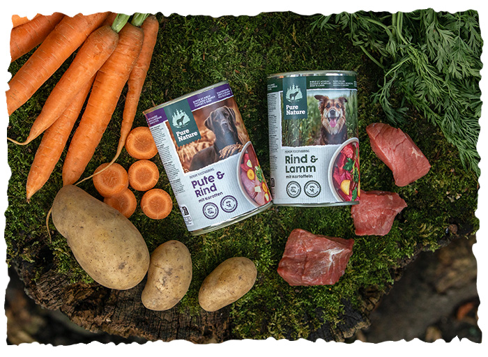 Two Pure Nature tins lying on a moss-covered tree trunk and surrounded by ingredients